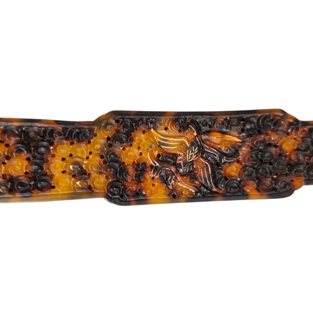 A late 19th-century Chinese Qing Dynasty ruyi sceptre carved from translucent mottled amber and dark brown tortoiseshell with intricate relief carving along the handle and head. View X