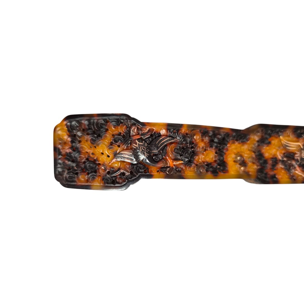 A late 19th-century Chinese Qing Dynasty ruyi sceptre carved from translucent mottled amber and dark brown tortoiseshell with intricate relief carving along the handle and head. View XI
