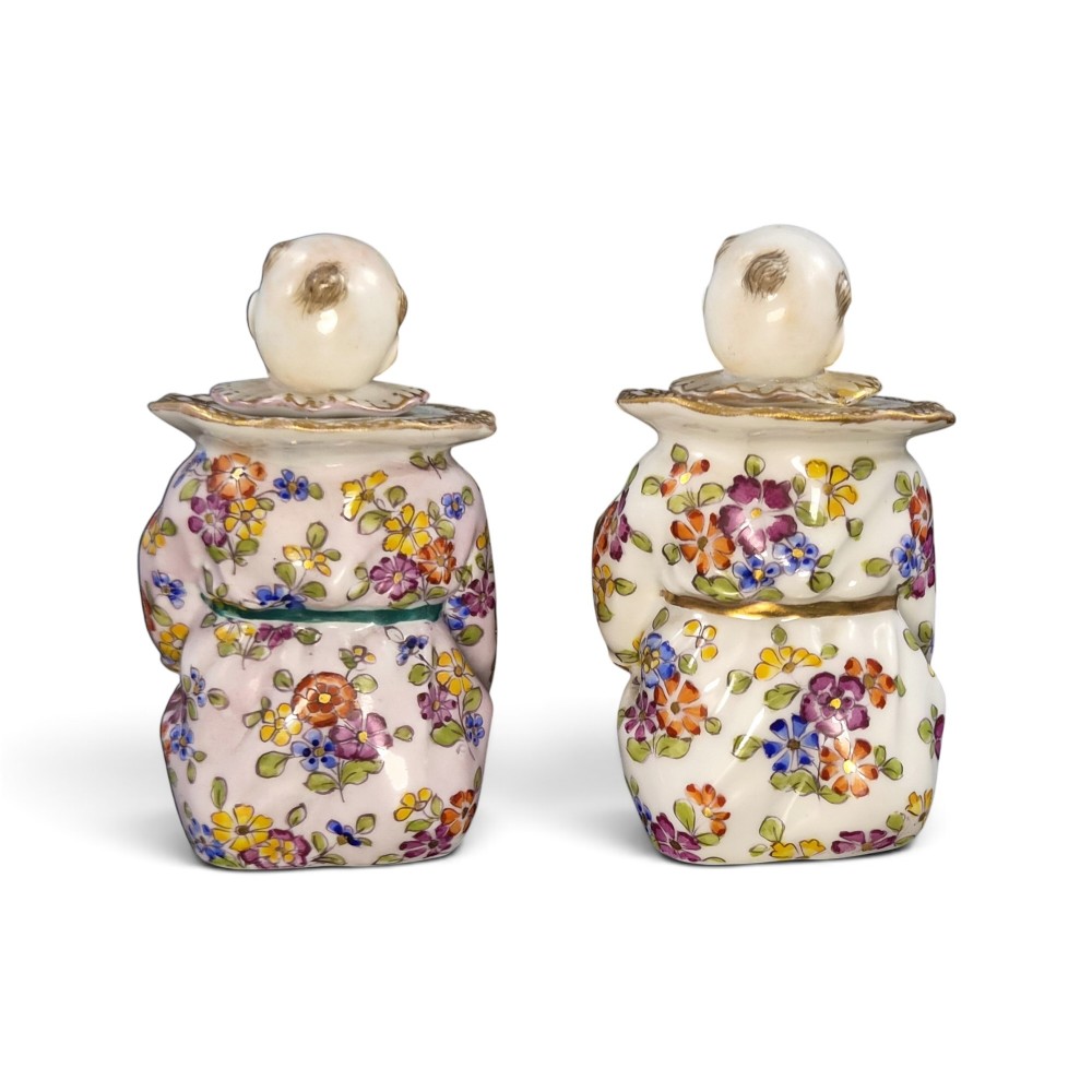 A pair of antique French Samson porcelain figural inkwells depicting singing boys wearing floral robes and gilt-rimmed ruffs while holding open songbooks. View III