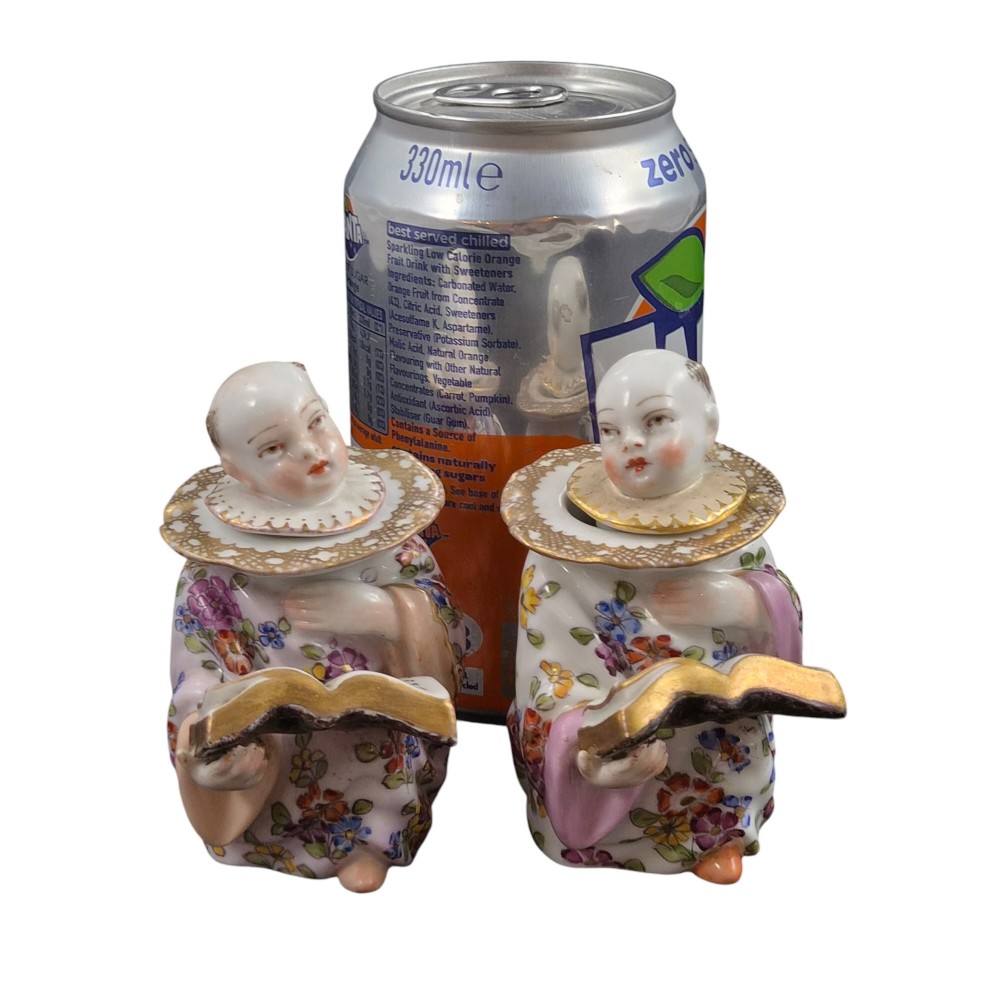 A pair of antique French Samson porcelain figural inkwells depicting singing boys wearing floral robes and gilt-rimmed ruffs while holding open songbooks. View XV