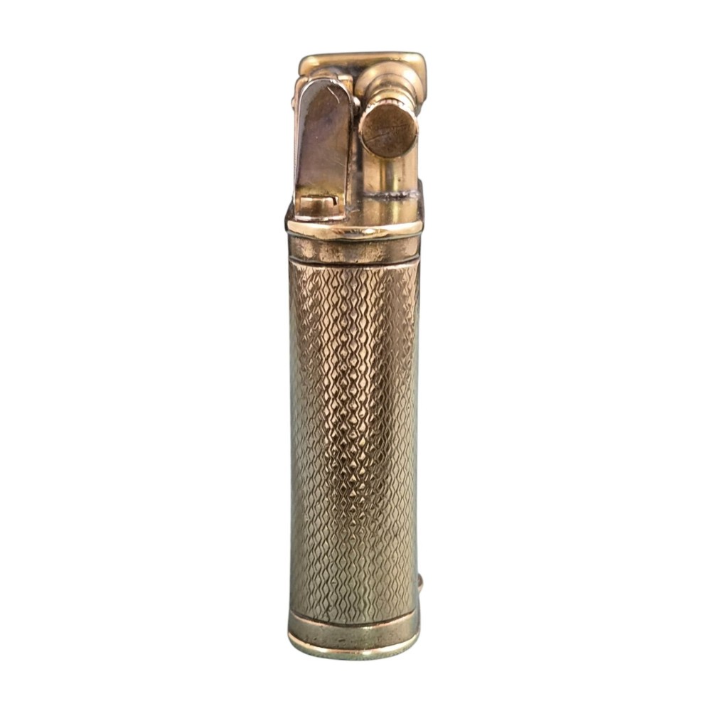 A 1920s Dunhill Unique gold-plated petrol lighter featuring an engine-turned pattern and a straight-arm lift mechanism. View II