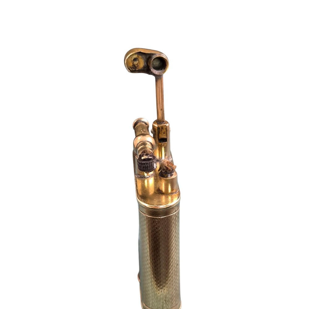 A 1920s Dunhill Unique gold-plated petrol lighter featuring an engine-turned pattern and a straight-arm lift mechanism. View VIII