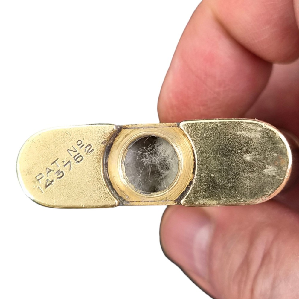A 1920s Dunhill Unique gold-plated petrol lighter featuring an engine-turned pattern and a straight-arm lift mechanism. View X
