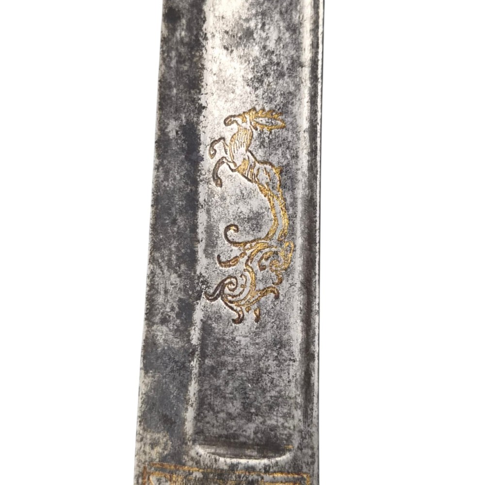 A 19th-century Pesh-Kabz knife featuring a recurved single-edged steel blade with surface etching, a brass bolster, and a tapered carved horn handle. View IX