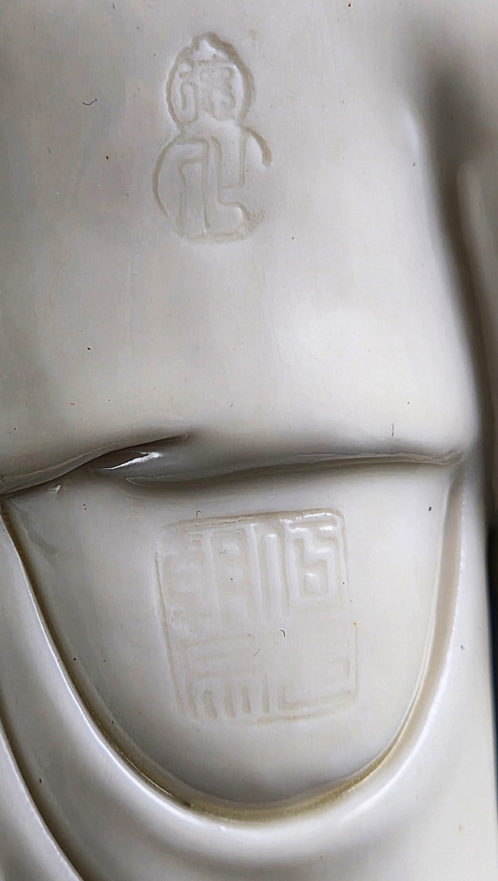 A cream white glazed porcelain figure group featuring two standing figures positioned on a lotus leaf and wave carved base. View X