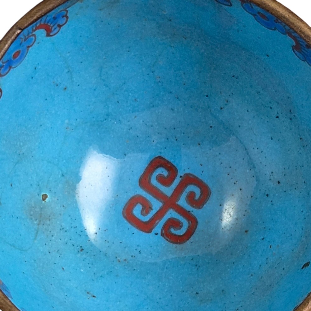 An eighteenth-century Chinese Canton enamel wine cup with green dragon-shaped handles resting on a matching round saucer, decorated with floral motifs and symbols. View V