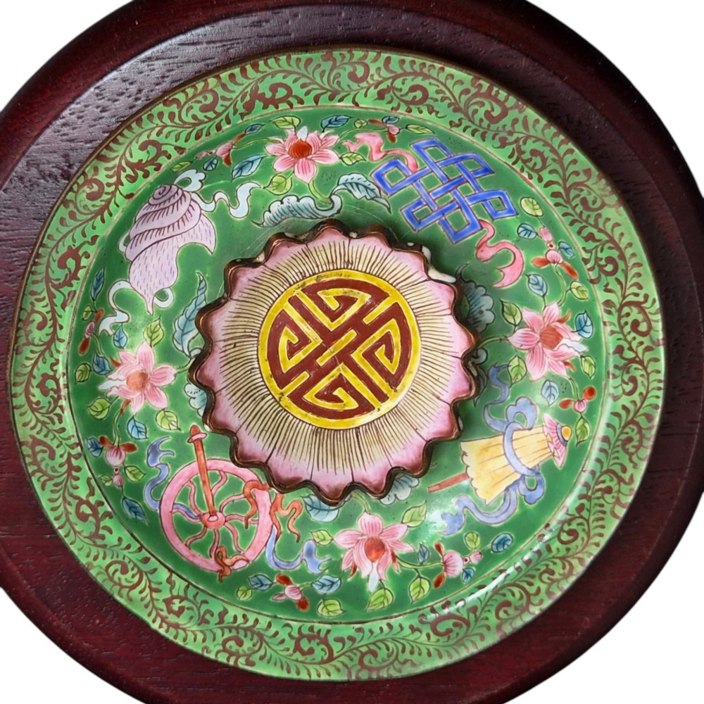 An eighteenth-century Chinese Canton enamel wine cup with green dragon-shaped handles resting on a matching round saucer, decorated with floral motifs and symbols. View IX