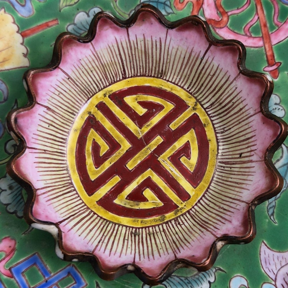 An eighteenth-century Chinese Canton enamel wine cup with green dragon-shaped handles resting on a matching round saucer, decorated with floral motifs and symbols. View XI