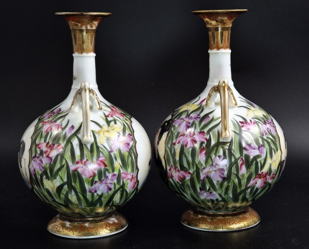 A pair of Japanese Yokohama porcelain vases decorated with hand-painted figures, floral irises, twin gilt handles, and gilded neck details. View II