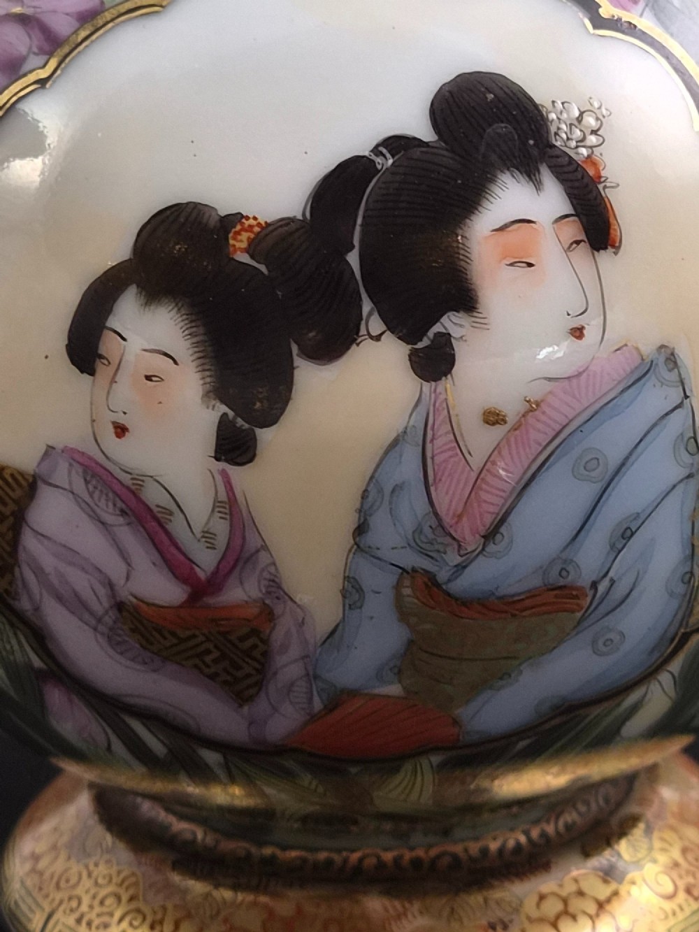 A pair of Japanese Yokohama porcelain vases decorated with hand-painted figures, floral irises, twin gilt handles, and gilded neck details. View XI