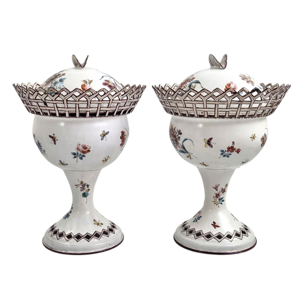 A pair of off-white 19th-century French tole peinte chestnut urns featuring hand-painted botanical motifs, pierced lattice galleries, and shell-form finials on the lids. View II
