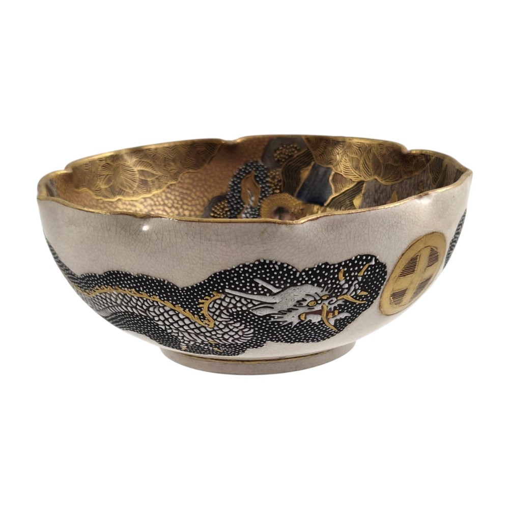 A lobed Japanese Satsuma earthenware bowl featuring detailed hand-painted figures of Rakan and a dragon accented with gold enamelling. View IV