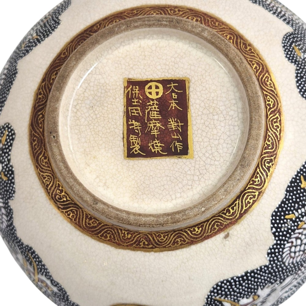 A lobed Japanese Satsuma earthenware bowl featuring detailed hand-painted figures of Rakan and a dragon accented with gold enamelling. View V