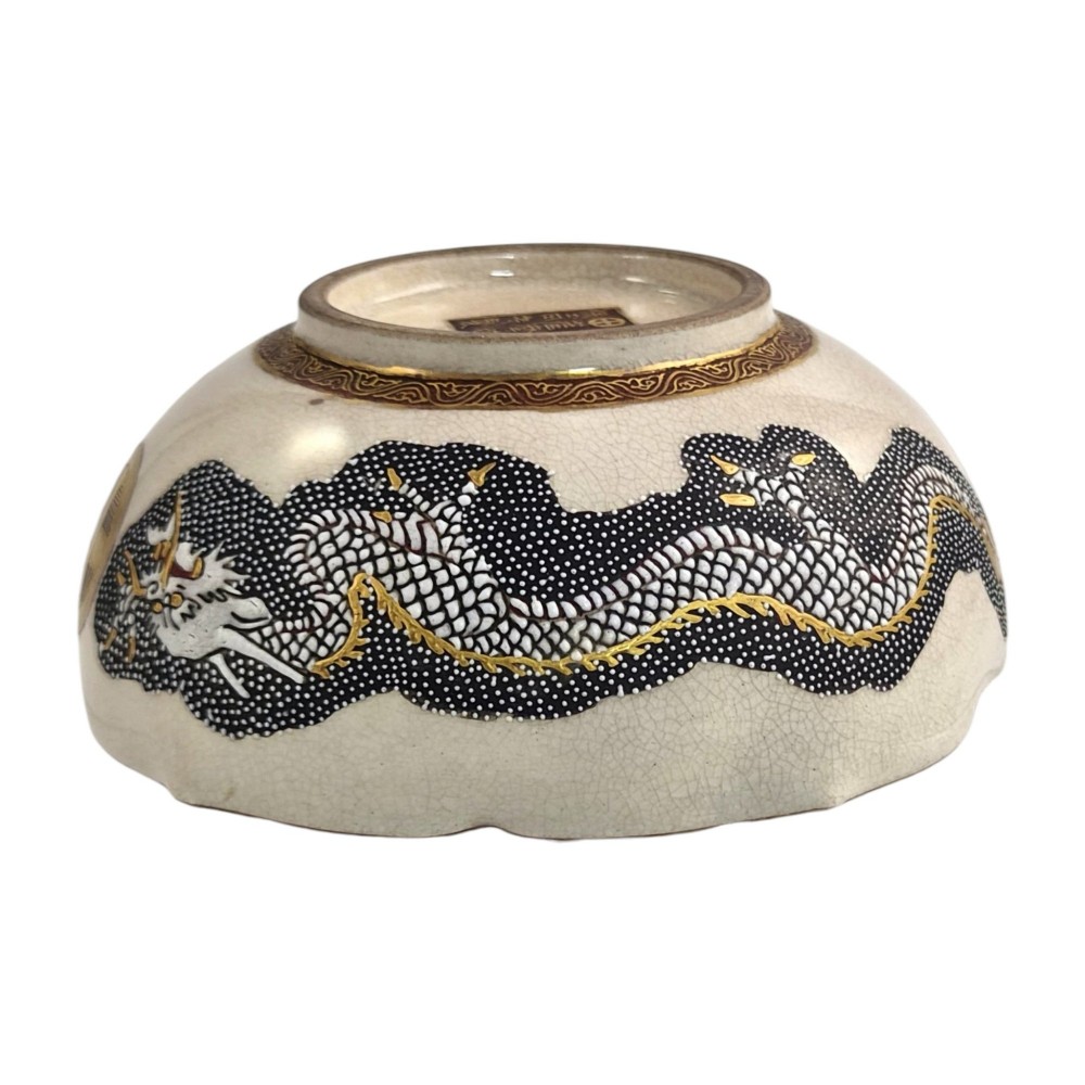 A lobed Japanese Satsuma earthenware bowl featuring detailed hand-painted figures of Rakan and a dragon accented with gold enamelling. View VI