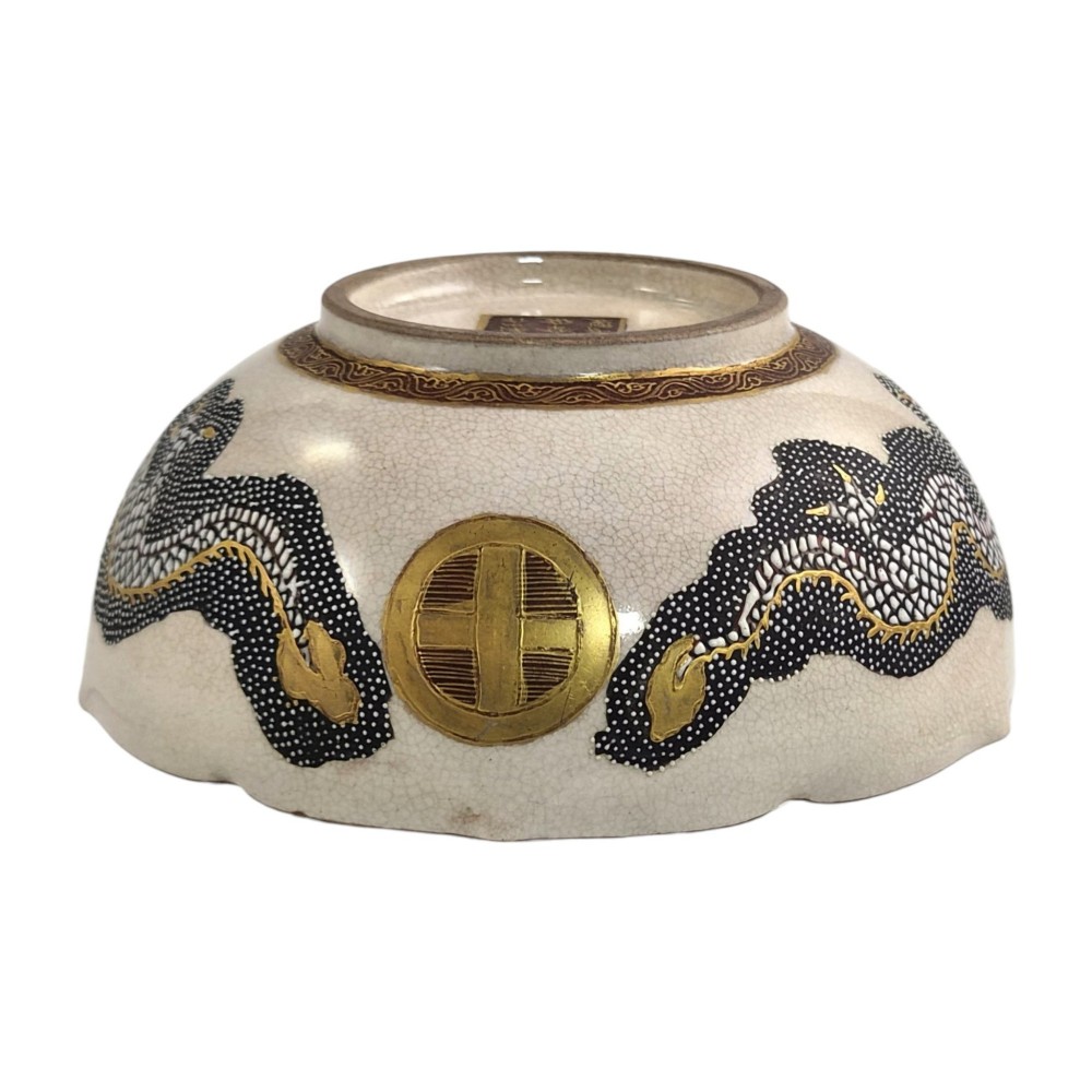 A lobed Japanese Satsuma earthenware bowl featuring detailed hand-painted figures of Rakan and a dragon accented with gold enamelling. View VII