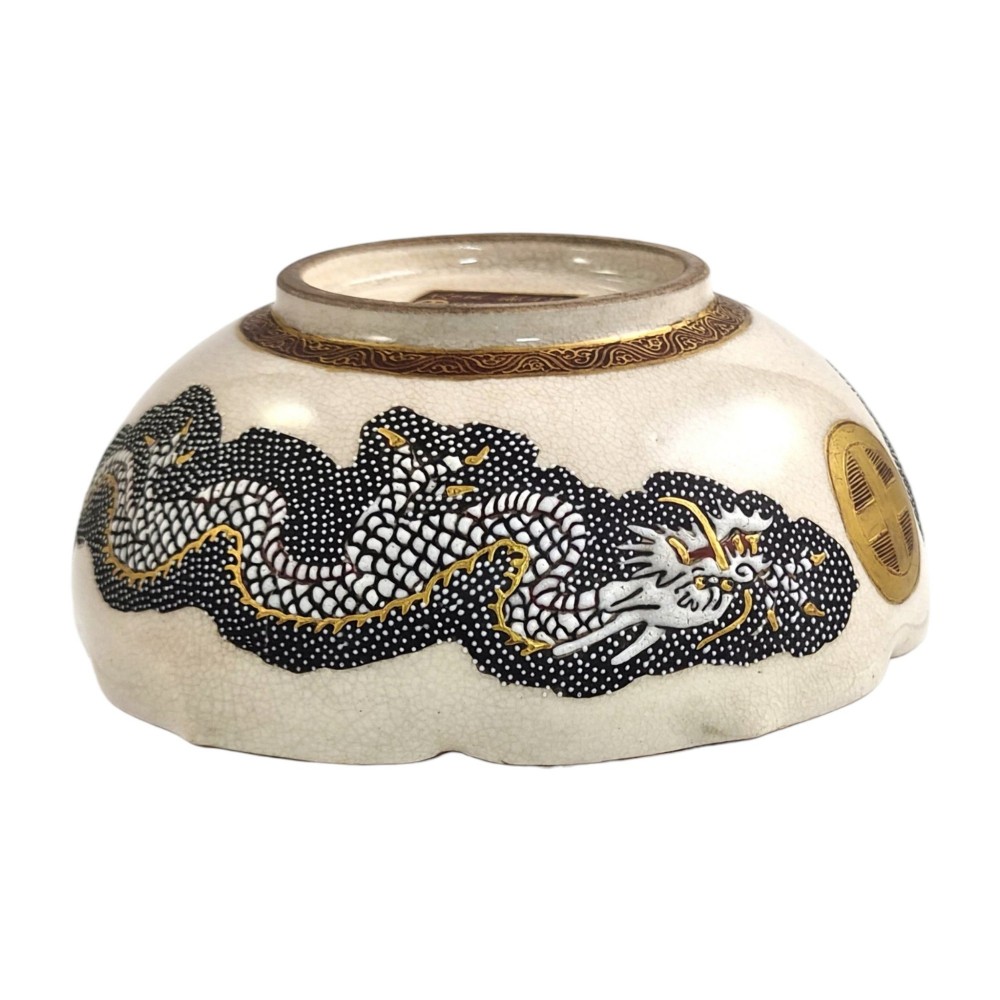 A lobed Japanese Satsuma earthenware bowl featuring detailed hand-painted figures of Rakan and a dragon accented with gold enamelling. View VIII