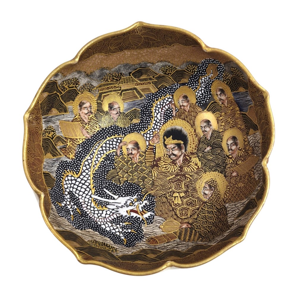 A lobed Japanese Satsuma earthenware bowl featuring detailed hand-painted figures of Rakan and a dragon accented with gold enamelling. View IX