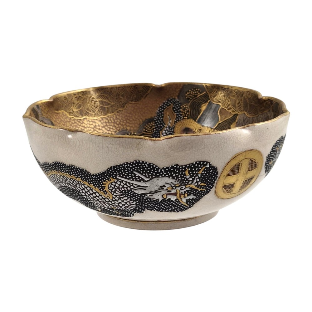 A lobed Japanese Satsuma earthenware bowl featuring detailed hand-painted figures of Rakan and a dragon accented with gold enamelling. View XI