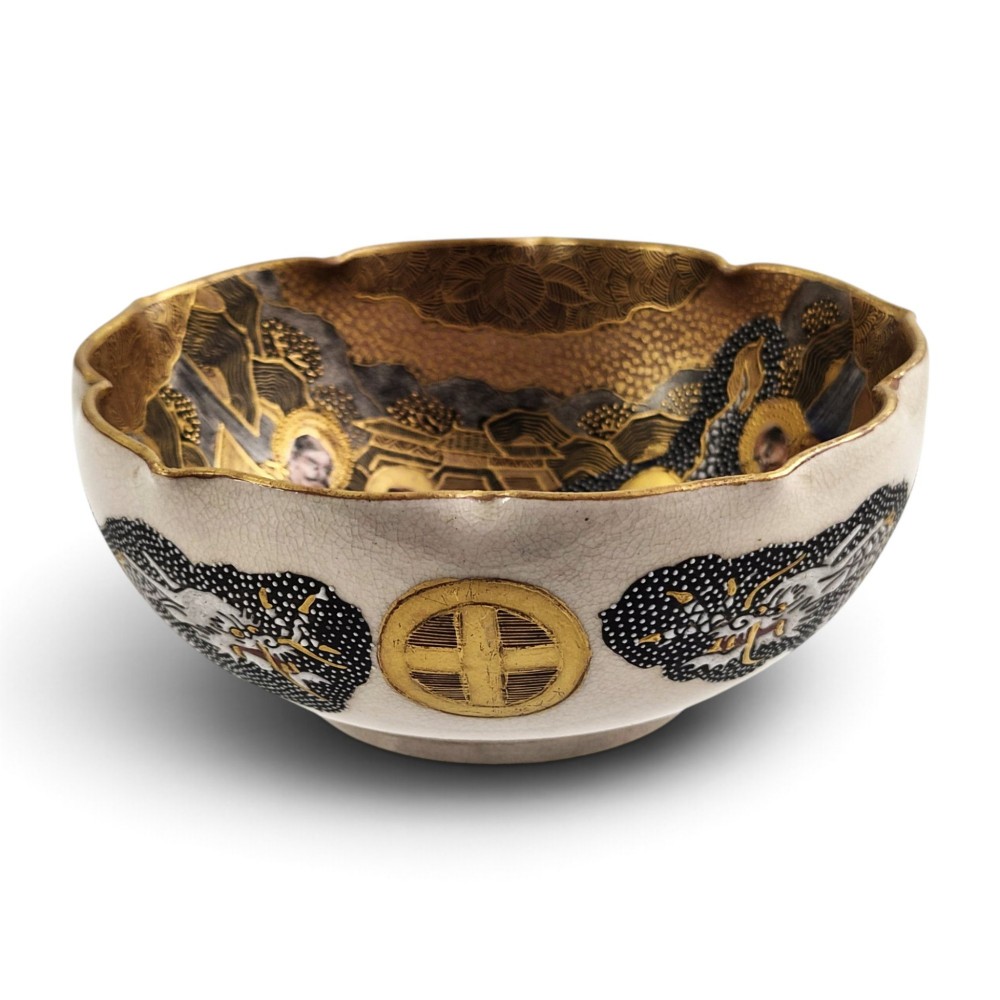 A lobed Japanese Satsuma earthenware bowl featuring detailed hand-painted figures of Rakan and a dragon accented with gold enamelling. View XII