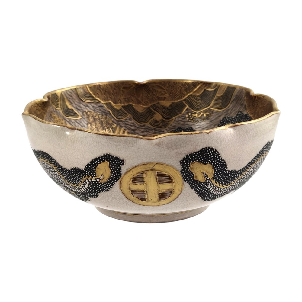 A lobed Japanese Satsuma earthenware bowl featuring detailed hand-painted figures of Rakan and a dragon accented with gold enamelling. View XIV