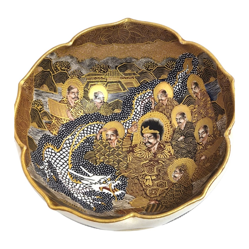 A lobed Japanese Satsuma earthenware bowl featuring detailed hand-painted figures of Rakan and a dragon accented with gold enamelling.