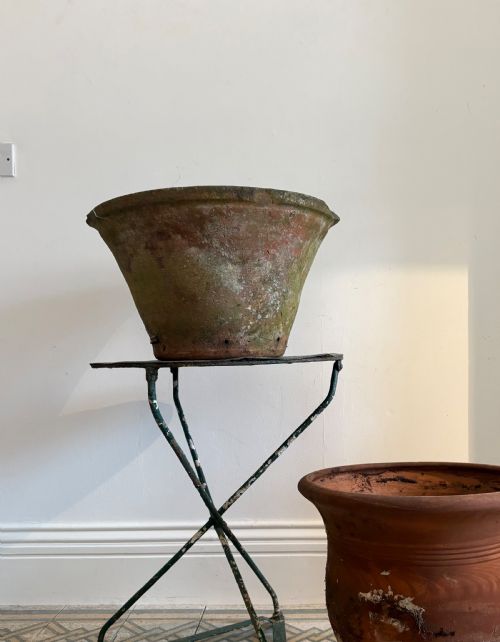 fig 2. A large 19th-century circular terracotta dairy bowl featuring a dark glazed interior and weathered, unglazed exterior surface.