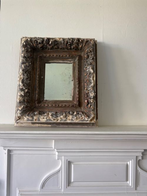 A 17THC CONTINENTAL CARVED WOOD AND GESSO FRAME WITH 18THC FOXED MIRROR 49CM