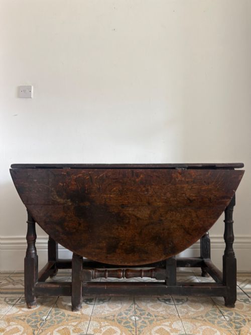 A LATE 17 TO 18TH CENTURY OAK PLANK TOP GATELEG TABLE WITH TURNED BALUSTER LEGS