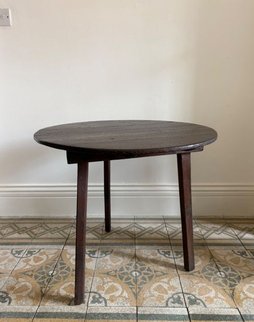 A 19TH CENTURY OAK PLANK TOP AND PINE BASE CRICKET TABLE 76CM DIAMETER