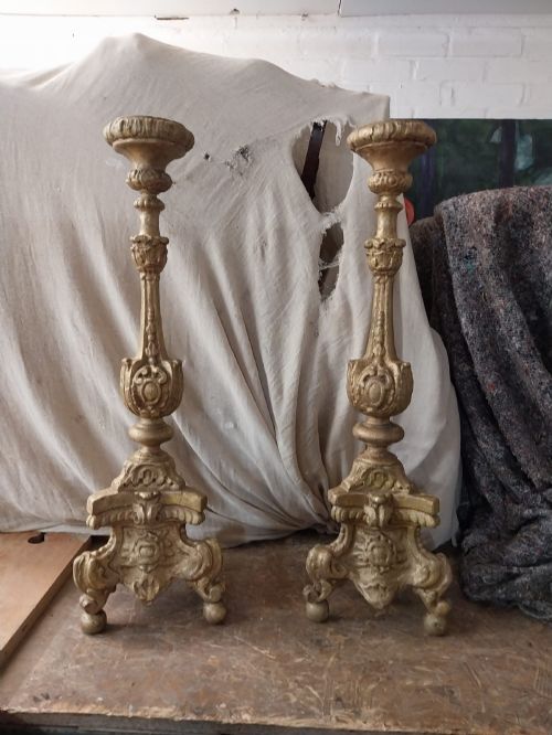 fig 1. A pair of 18th-century Italian Baroque carved giltwood altar candlesticks featuring triform bases with scrollwork and tall baluster stems.