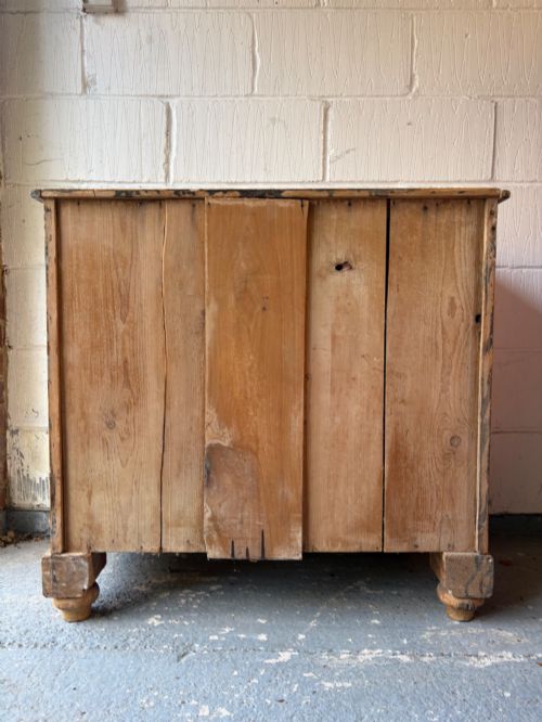 fig 1. A nineteenth-century scrubbed pine chest of drawers with two small drawers above two long drawers featuring dark turned bun handles.