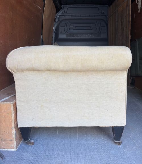 fig 2. A large 19th-century Victorian Chesterfield sofa upholstered in cream calico linen featuring deep rolled arms and tapered dark timber legs with brass castors.