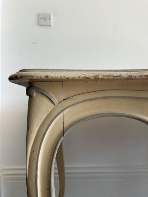 fig 1. A cream painted French console table featuring long cabriole legs, a shaped apron with subtle trim, and an inset suede tabletop.