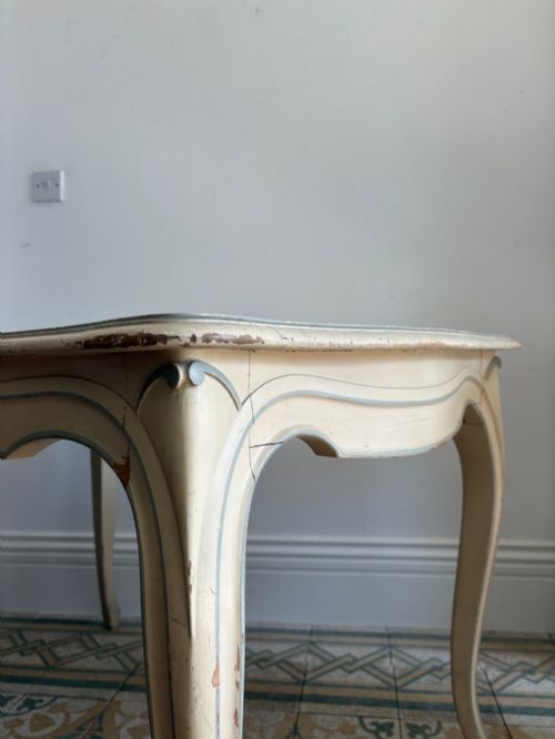 fig 3. A cream painted French console table featuring long cabriole legs, a shaped apron with subtle trim, and an inset suede tabletop.