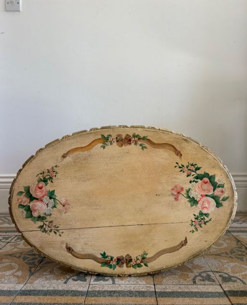 fig 1. An oval cream-painted mahogany occasional table with hand-painted floral garlands, fluted apron, and square tapered fluted legs.