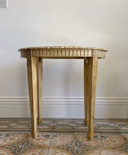 fig 3. An oval cream-painted mahogany occasional table with hand-painted floral garlands, fluted apron, and square tapered fluted legs.