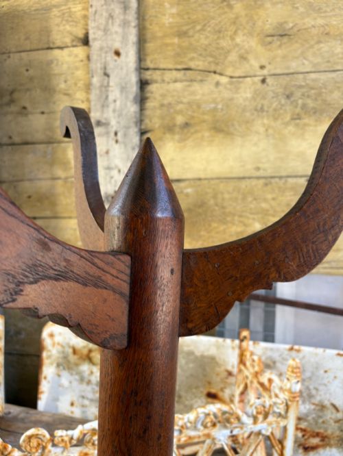 fig 2. An English Arts and Crafts solid oak wine table featuring a circular top, an under-top support bracket, a central column terminating in a pointed lower finial, and three splayed cabriole legs.