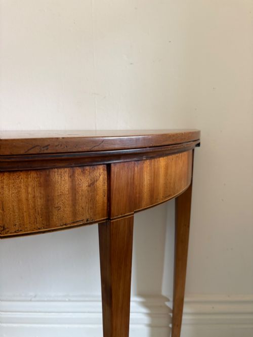 fig 1. A late 18th-century George III semi-circular demi-lune folding table crafted from cherrywood and elm with four tapered square legs.