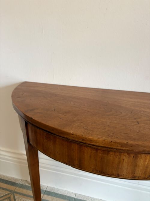 fig 3. A late 18th-century George III semi-circular demi-lune folding table crafted from cherrywood and elm with four tapered square legs.