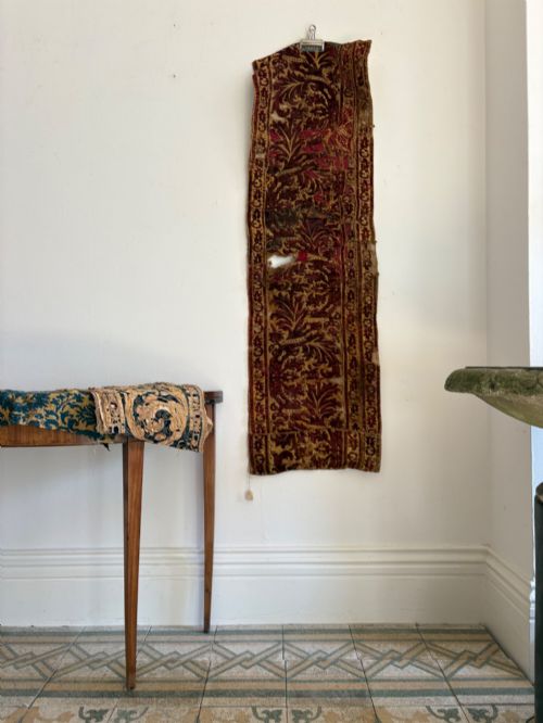 fig 2. A long vertical 17th-century Italian crimson velvet textile fragment with gold silk acanthus leaf embroidery and patterned borders.