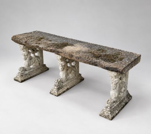 fig 1. A weathered stone garden bench featuring a rectangular York stone top resting on three cast stone griffin pedestals.