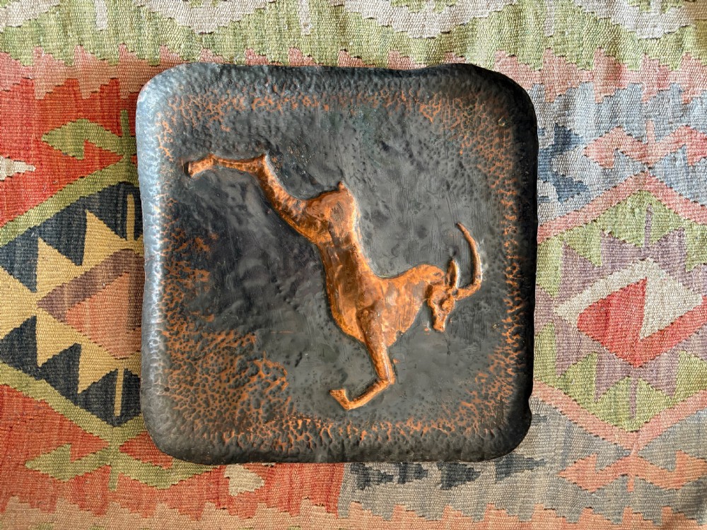 A pair of square late 19th-century hammered metal trays with raised repousse animal figures of an ibex and a feline. View IV