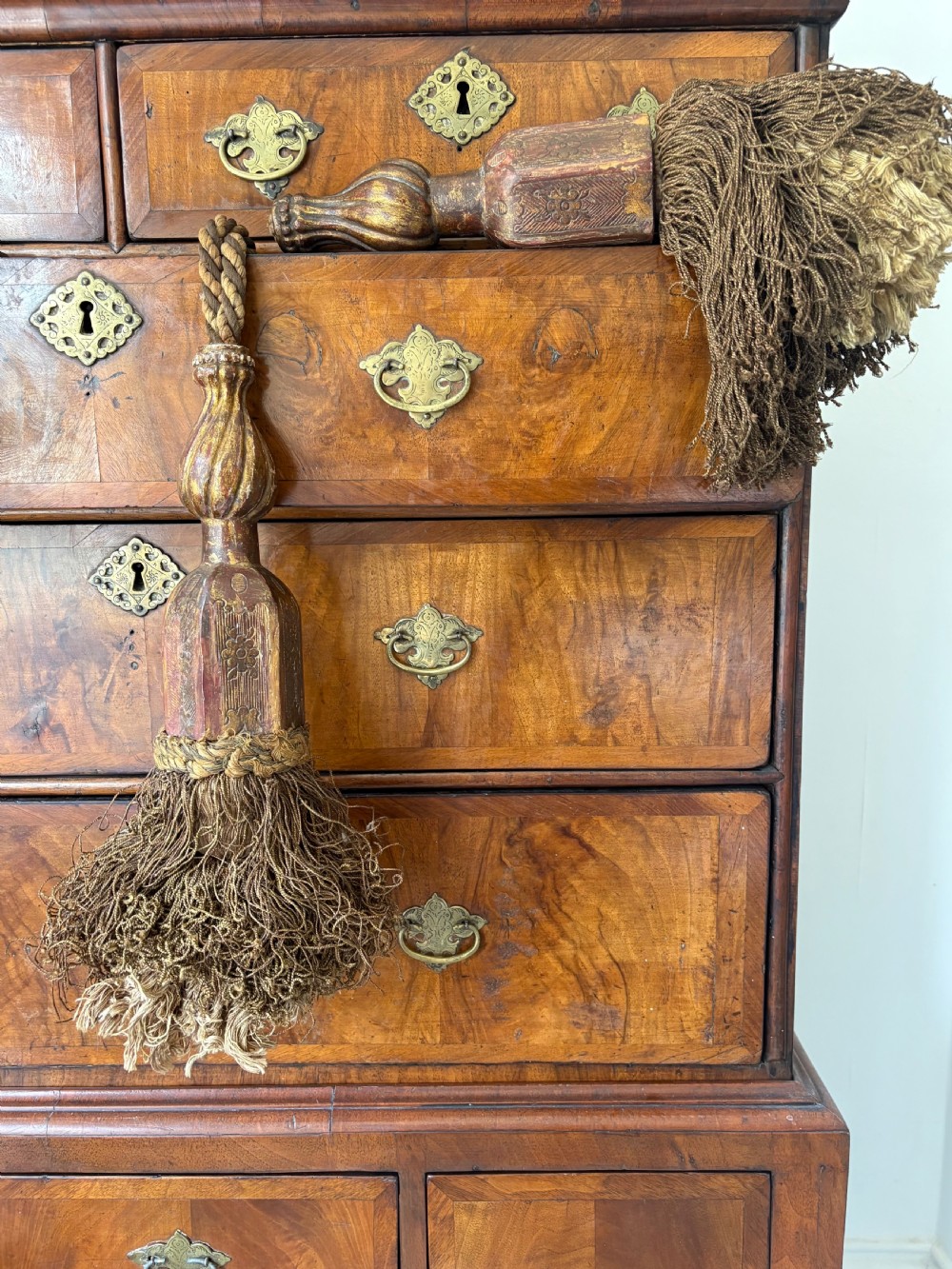 A pair of 19th-century Venetian curtain tiebacks with carved giltwood turned tops and dense fibrous tassels suspended by a chain and cord. View II