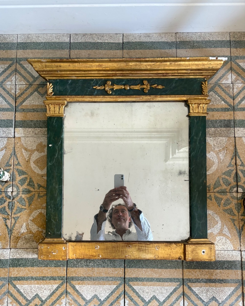 An early 19th-century Neoclassical rectangular wall mirror featuring a giltwood cornice and base flanking green faux-marble painted pilasters and frieze.
