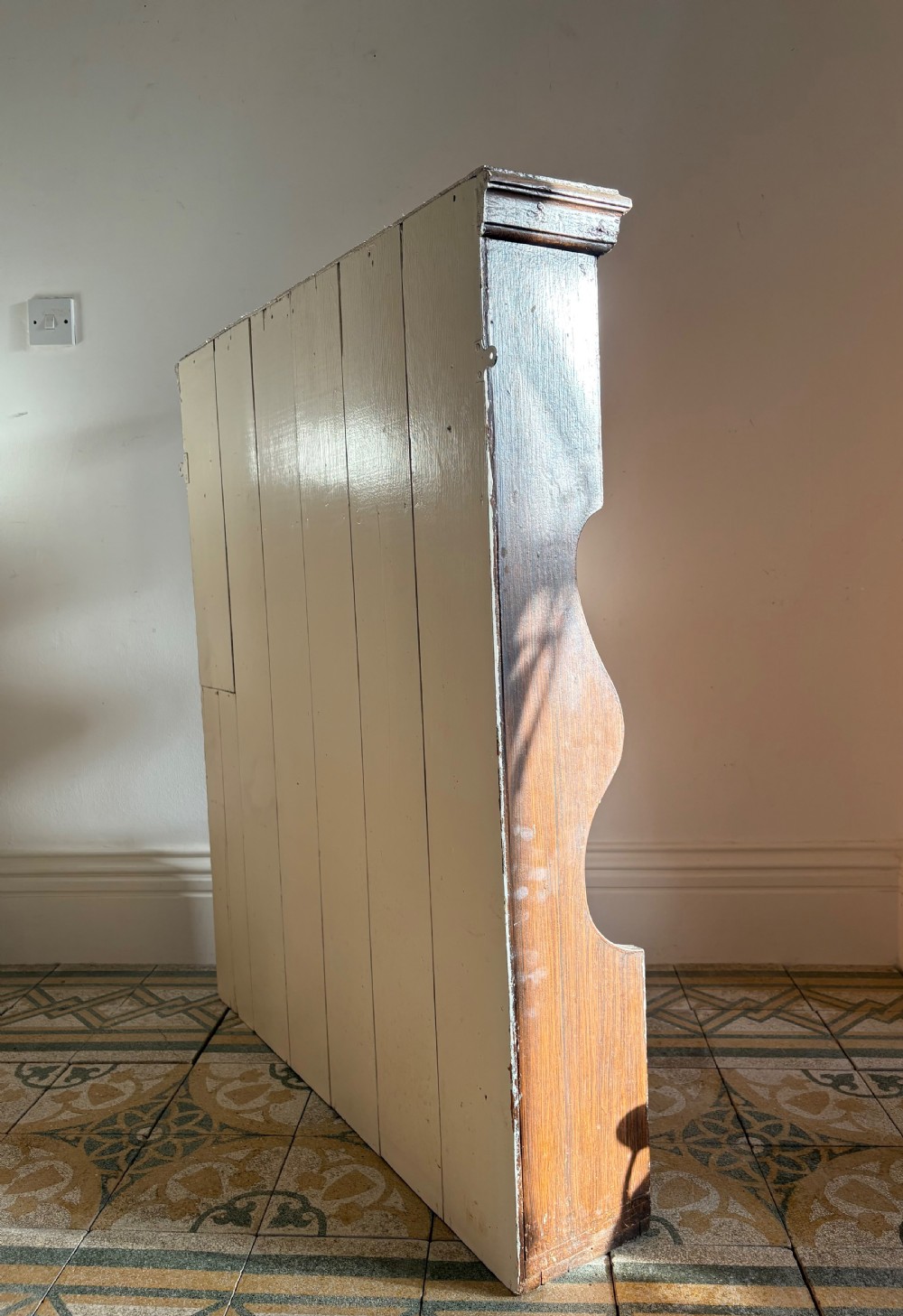 A 19th-century dark brown painted pine waterfall shelving unit featuring four open graduated shelves with curved sides. View III