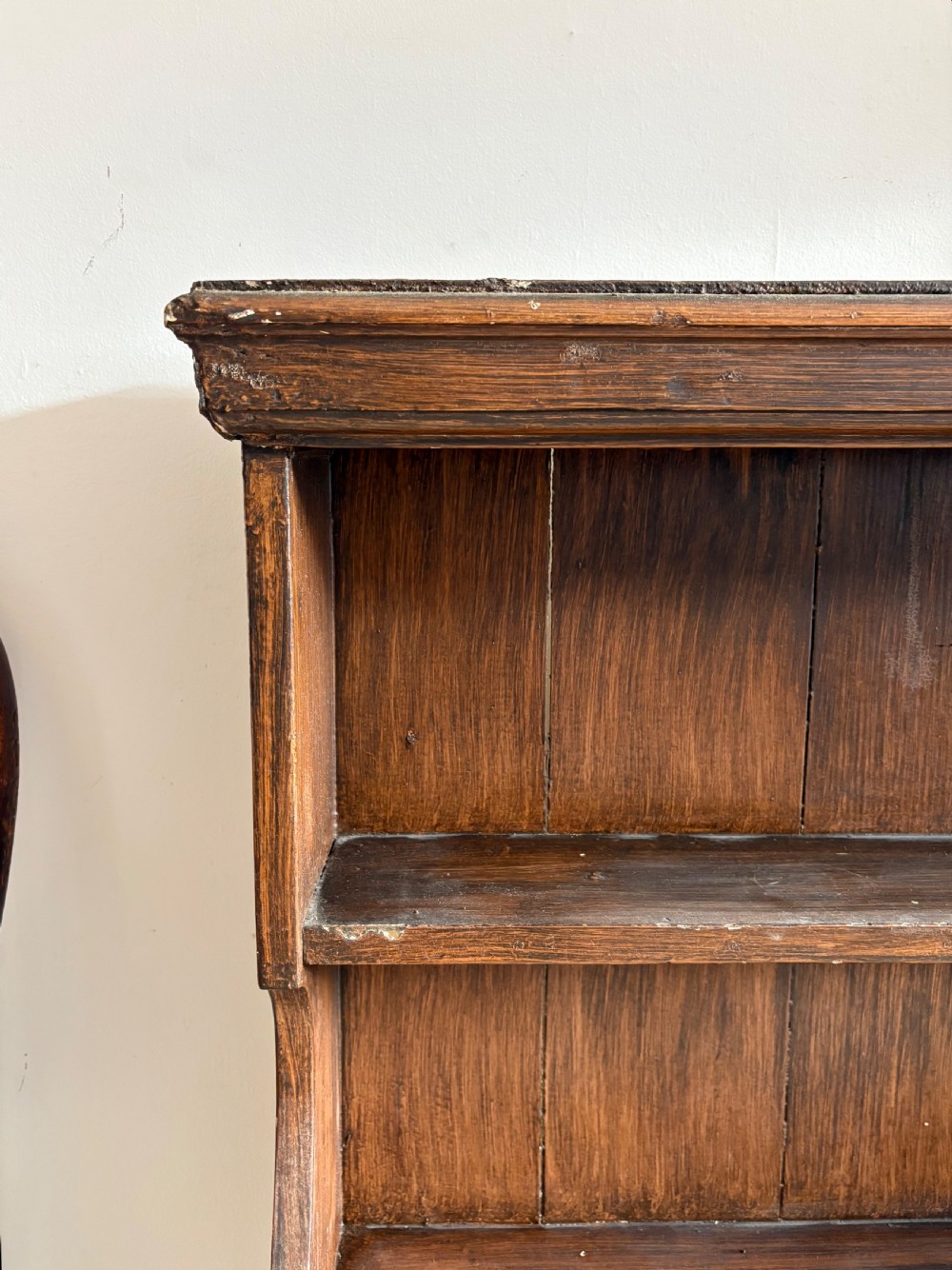 A 19th-century dark brown painted pine waterfall shelving unit featuring four open graduated shelves with curved sides. View IX