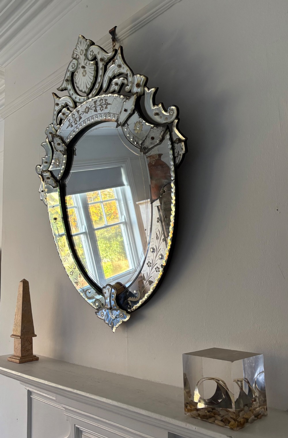 An oval Venetian wall mirror featuring an etched glass frame with floral motifs, a scrollwork crest, and a bevelled centre mirror with light foxing. View III