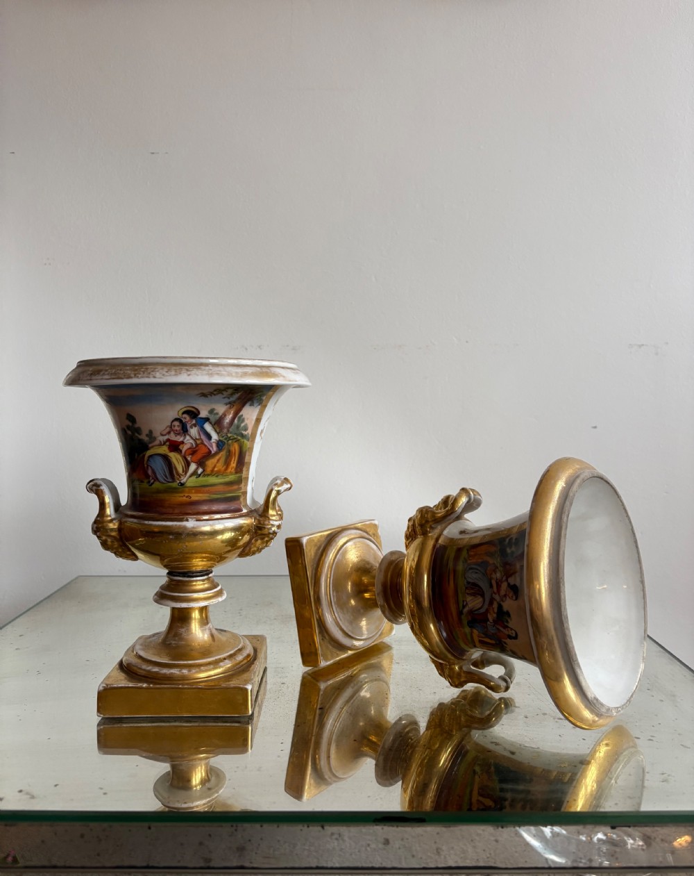 A pair of 19th-century French Paris porcelain urn vases featuring hand-painted figurative scenes and burnished gold bases. View II