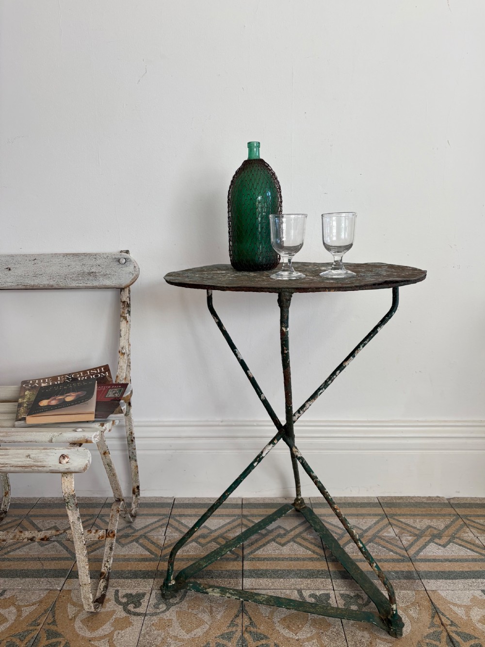 A 19th-century French cast iron gueridon round table featuring distressed green paint and a triangular tripod base. View X