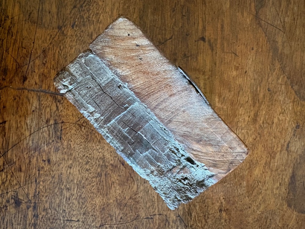 A small hand-carved dark oak architectural fragment featuring relief detail and a metal mounting loop at the top. View IX